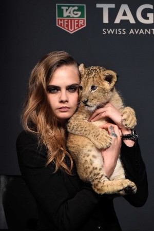 Model Cara Delevingne walks the runway with a lion as she joins TAG Heuer as Brand Ambassador to launch the new 2015 campaign at Palais des Beaux-Arts on January 23, 2015 in Paris, France.