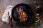 Grilled Ribeye steak entrecote on grill pan on wooden background