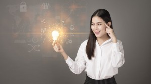 Intelligent woman is holding light bulb with business and financial  data